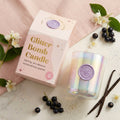 BLOOMTINE Glitter Bomb pink sparkle candle inside an opulent pink glass vessel. A luxury patchouli vanilla candle displaying a melted pool of shimmering pink soy wax