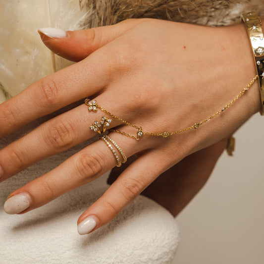 Hand wearing gold rings and a bracelet with a neutral background. Lifestyle-image of a woman-wearing the Enchanting-Flutterfly-sterling-silver-ring. The-photo demonstrates the-dainty-stackable-silhouette, showing how the-butterfly-motif sits elegantly on the-finger. Styled-for-effortless-beauty, this-image illustrates the-ring's-proportions for solo-wear or layering, making it an-ideal-example of everyday-luxury-wear and a-sentimental-gift-for-her