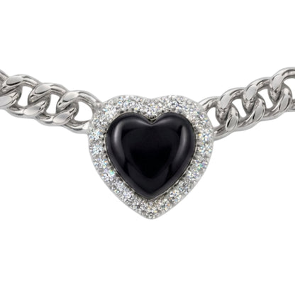 A silver-toned chain bracelet featuring a heart-shaped charm with a glossy black center and a halo of clear pavé stones, shown on a plain white background.