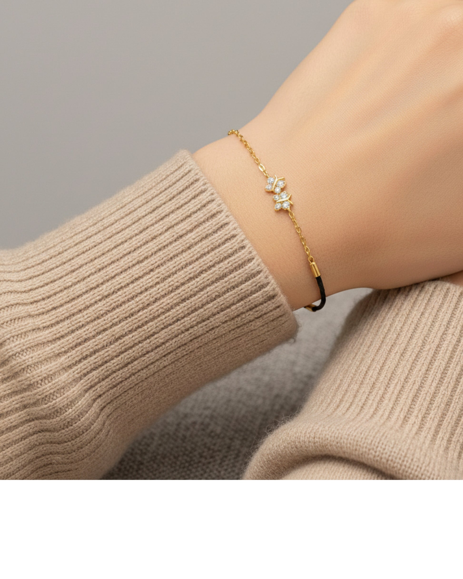 Gold bracelet with a star design on a wrist wearing a beige sweater.