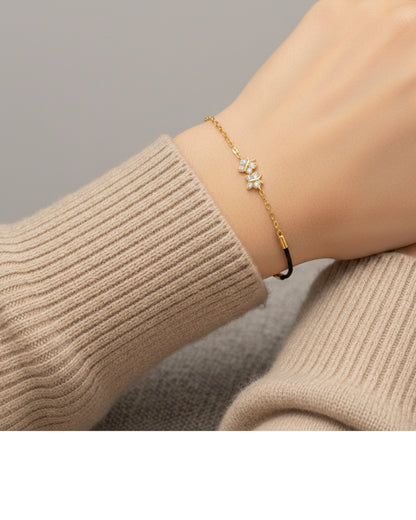 Gold bracelet with a star design on a wrist wearing a beige sweater.