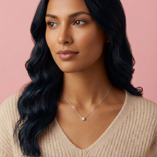 Woman wearing a necklace against a pink background