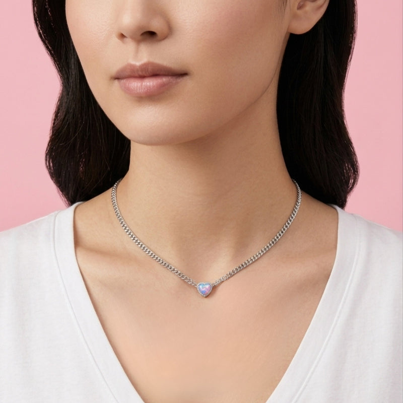 Woman wearing a necklace with a pink gemstone against a pink background