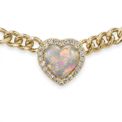 A gold chain bracelet featuring a heart-shaped opal pendant surrounded by a halo of small clear stones, shown against a plain white background.