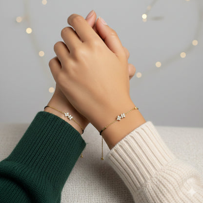 Two hands wearing delicate bracelets against a soft background