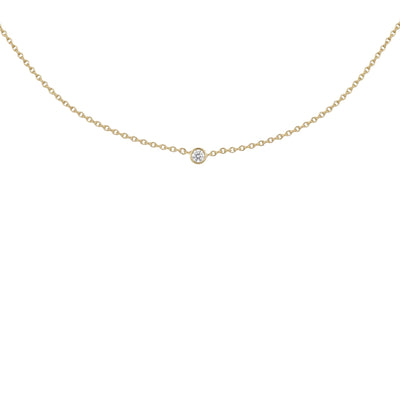 A delicate gold chain necklace with a single small round clear gemstone pendant, displayed against a solid white background.