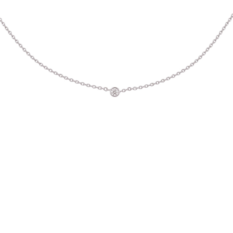 A delicate silver chain necklace with a single small round-cut gemstone at the center, displayed against a solid white background.