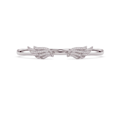 A delicate silver ring featuring two small wing motifs paved with clear stones, centered on a plain white background.