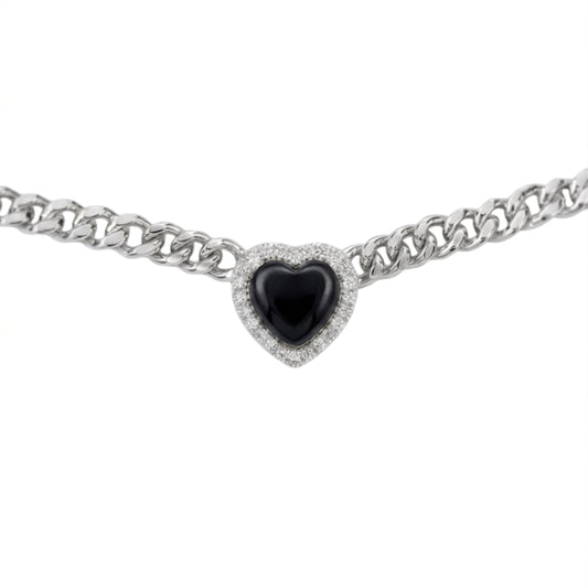 A silver-toned curb chain bracelet featuring a heart-shaped centerpiece with a glossy black center stone surrounded by a halo of small clear stones, shown against a plain white background.