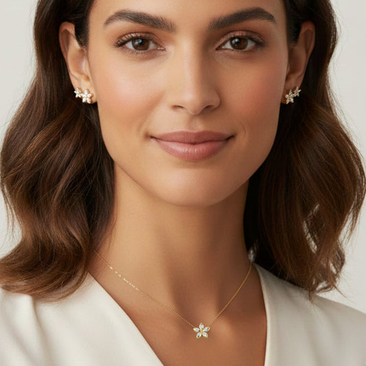 Bloomtine-model-wearing-gold-flower-necklace. A professional-lifestyle-image of a woman-wearing-a-gold-necklace-with-a-small-flower-pendant against a soft-neutral-background. This-botanical-necklace is crafted-in-18kt-gold-vermeil featuring a dainty-blossom-design on a fine-gold-chain. The-image-highlights the-scale-and-fit of the Bloomtine-eternal-bloom-collection, showing how the-gold-floral-jewellery sits-on-the-neckline as the-perfect-minimalist-gift-for-her