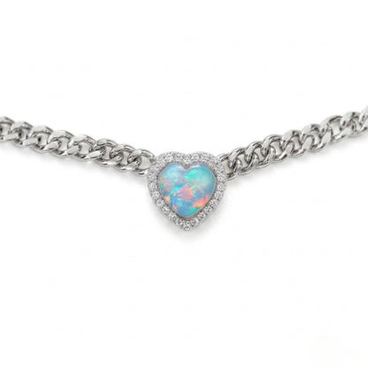 A silver-tone chain bracelet featuring a heart-shaped opal pendant with a halo of small clear stones, shown against a plain white background.
