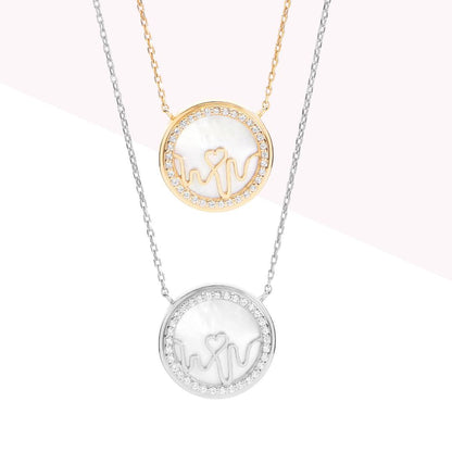 Bloomtine-Loves-Frequency-gold-vermeil-heartbeat-locket. A professional-high-resolution-product-photograph of an-18kt-gold-vermeil-heart-locket on a-crisp-white-background. This-detailed-view showcases the-multiple-shimmering-gemstones meticulously-set-along the-heartbeat-rhythm-path. The-image-highlights the-flawless-polished-finish and the-intricate-symbolic-engraving of the Bloomtine-signature-collection, making it an-exquisite-luxury-gift-choice for sentimental-occasions and milestone-celebratio