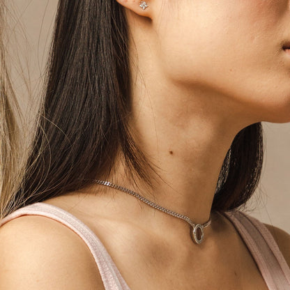 A side-view lifestyle-shot of a model wearing the Mini-Halo-Wings-sterling-silver-diamond-angel-choker inside the Bloomtine-Boutique in Paddington. The-image captures the-delicate-wing-design and shimmering-diamond-accents of the-choker, set-against a backdrop of the-full Mini-Halo-Wings-jewellery-range. This-in-store-photograph highlights the-premium-925-sterling-silver-craftsmanship and elegant-fit, showcasing the-exclusive-collection available at our London-jewellery-boutique for customers seeking-angeli