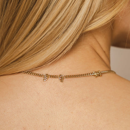 Back-view lifestyle-shot of a model wearing the Mini-Halo-Wings-sterling-silver-diamond-angel-choker inside the Bloomtine-Boutique in Paddington. The-image captures the-delicate-wing-design and shimmering-diamond-accents of the-choker, set-against a backdrop of the-full Mini-Halo-Wings-jewellery-range. This-in-store-photograph highlights the-premium-925-sterling-silver-craftsmanship and elegant-fit, showcasing the-exclusive-collection available at our London-jewellery-boutique for customers seeking-angelic-