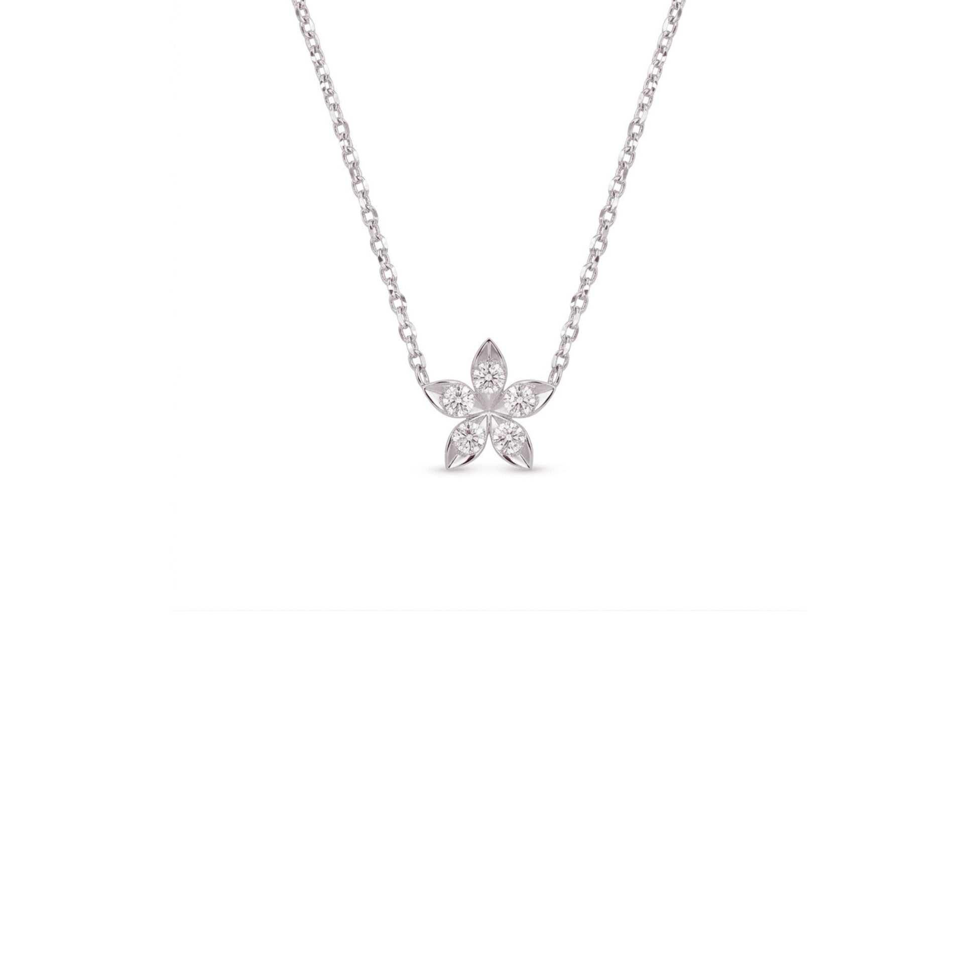 A delicate silver chain necklace with a small flower-shaped pendant set with clear stones, centered against a solid white background.